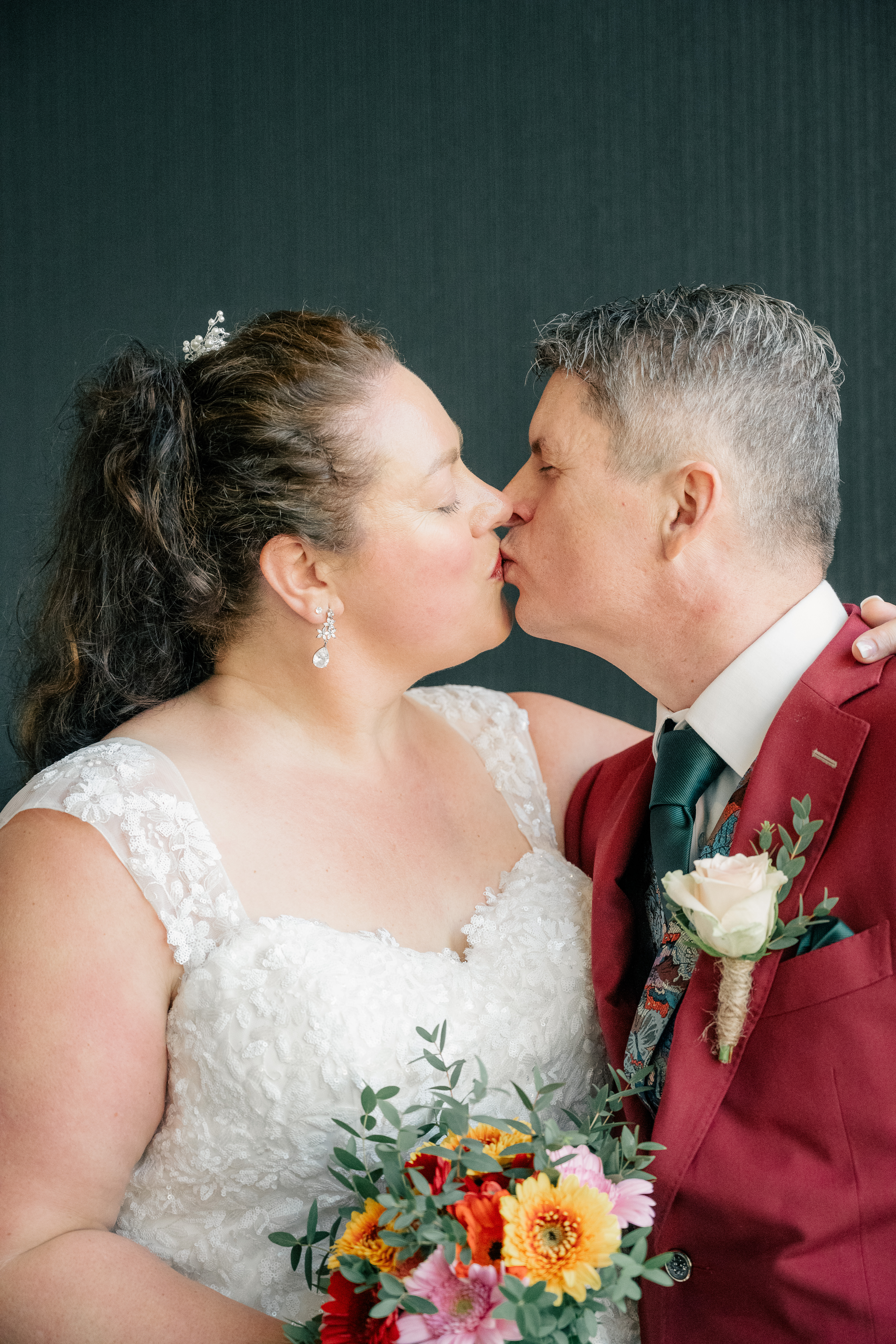 bride and groom share a kiss after family formal portraits