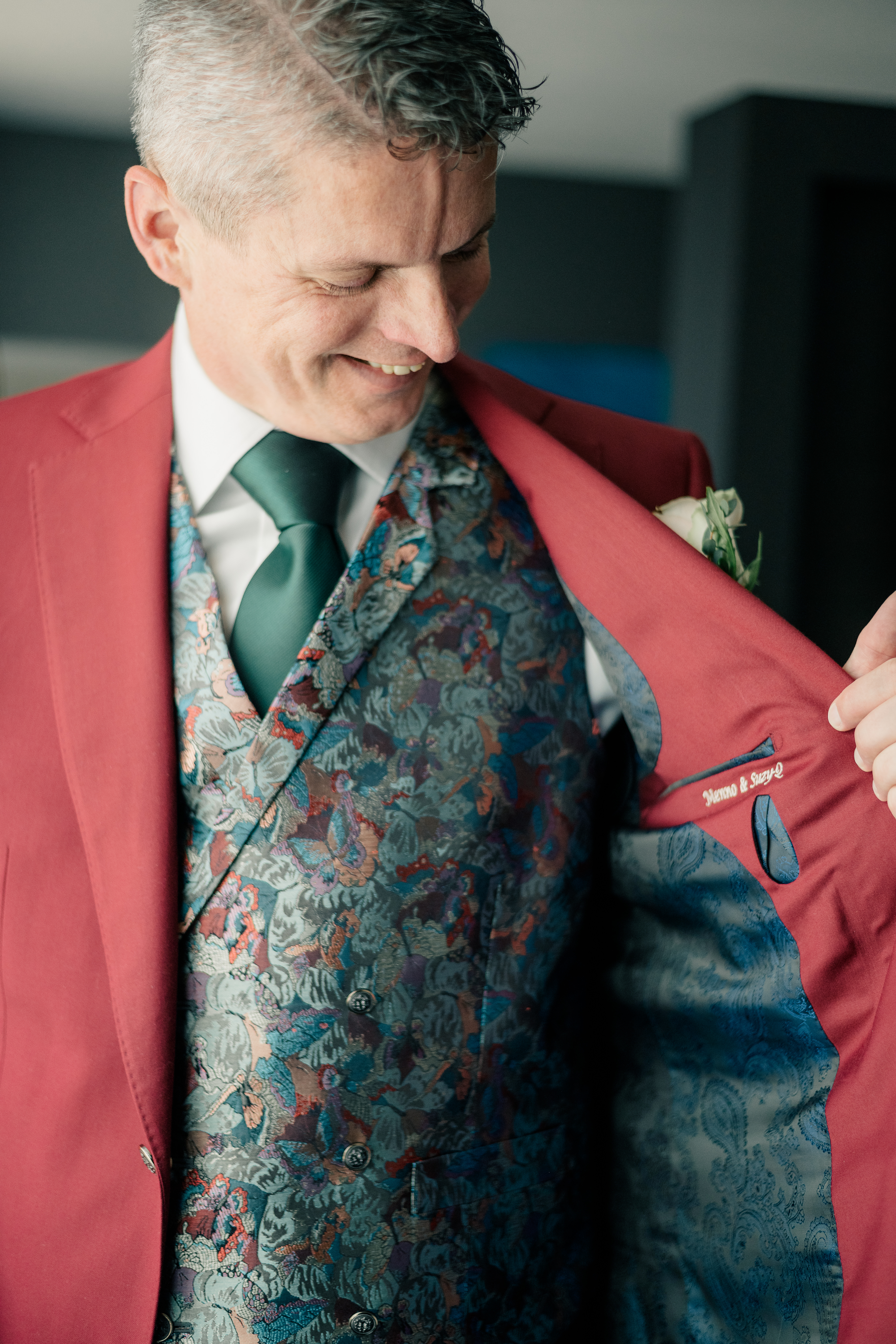 proud groom shows off his custom embroidery inside of three piece suit.