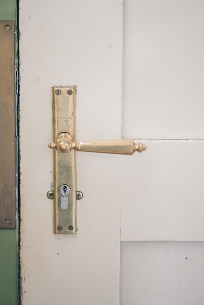 Detail view of old doorknob on cream door in municipal monument home in Nuenen