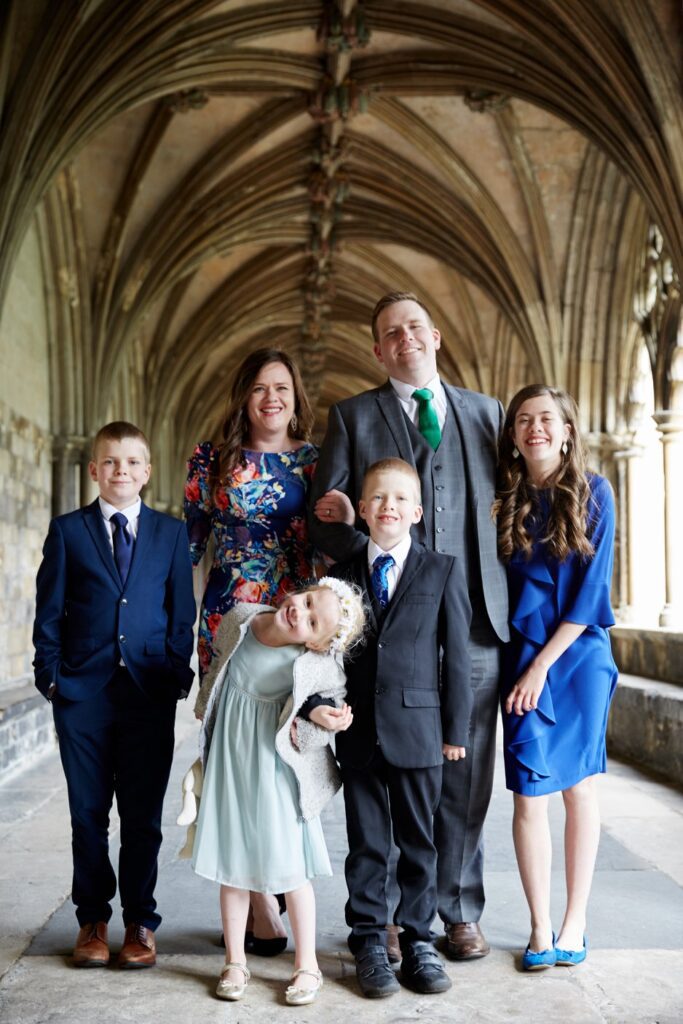 A family stands for a portrait in Norwich cathedral cloister 