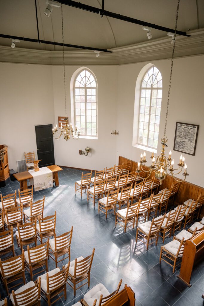 View of nearly whole church hall, baptismal font, and door to kitchen from balcony