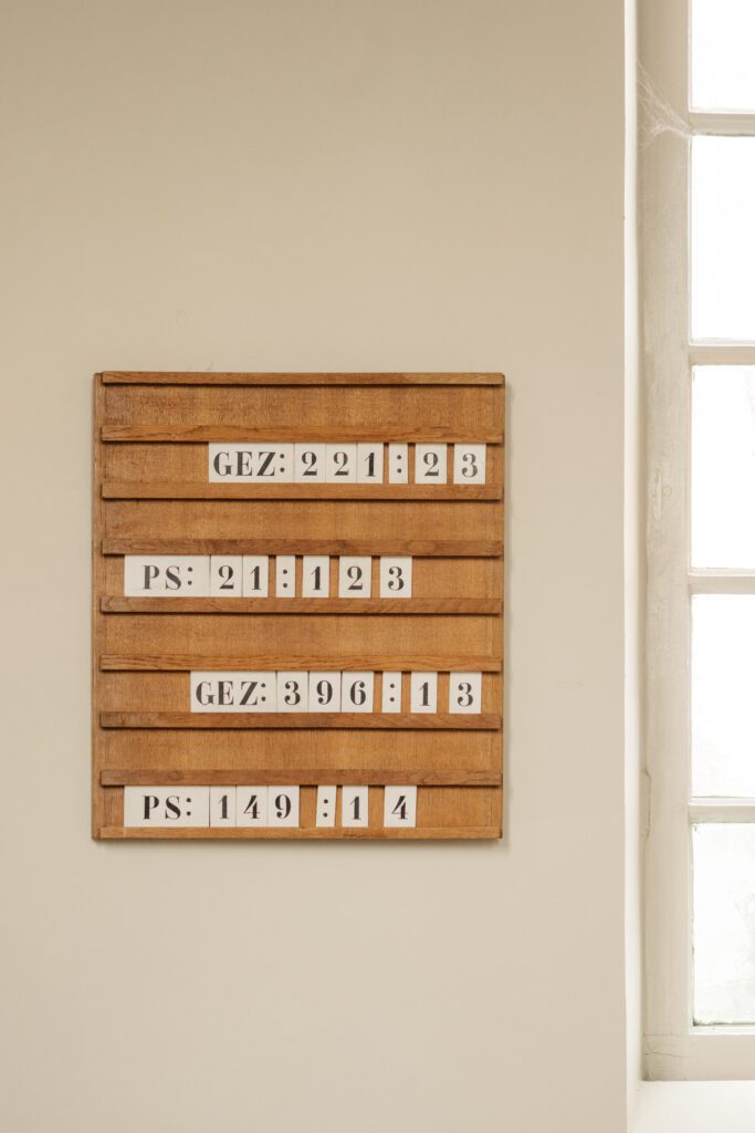 view of wooden board with hymn numbers listed and part of an antique window