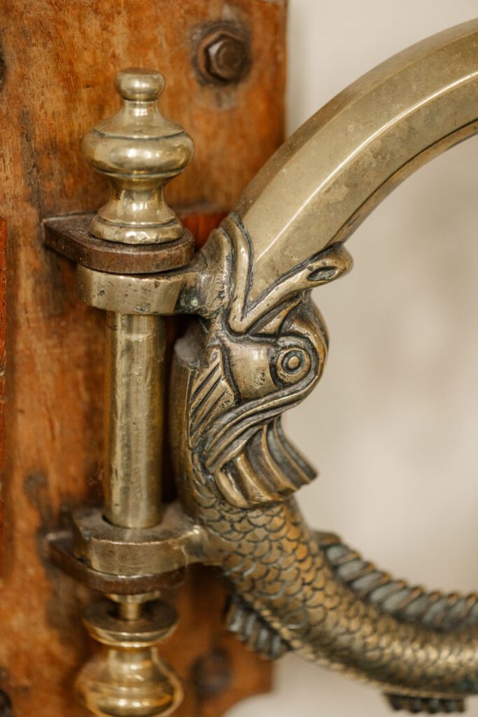 Detail of hinge on original baptismal font in the shape of a brass fish