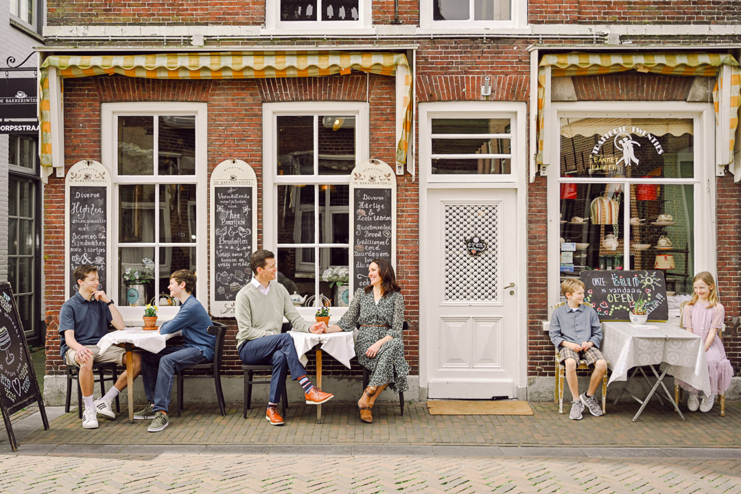 a family of six sits on chairs in front of a traditional Dutch bakery in Zoetermeer