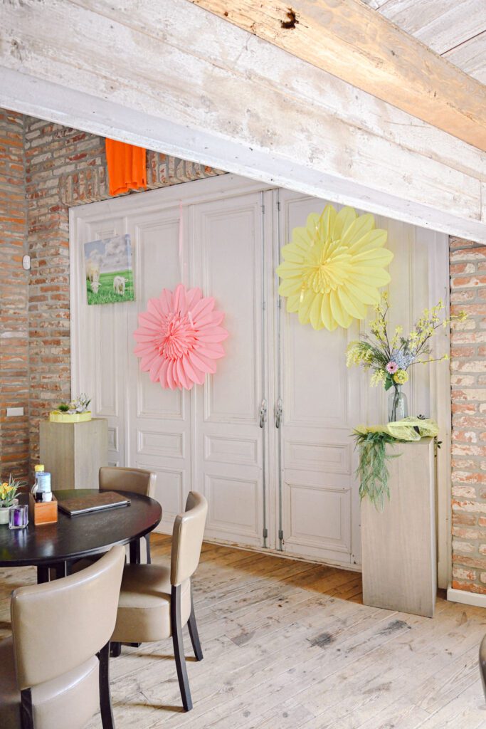 Old white barn doors and wooden beams are decorated in playful Spring colours